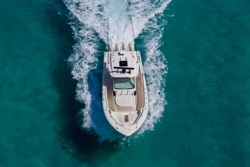  Yacht Photos Pics 2025 Grady-White Canyon 456 boat cruising on clear turquoise water.