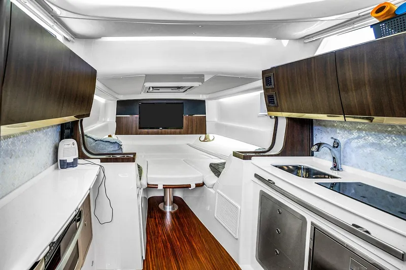 Yacht Photos Pics Luxurious interior of 2025 Grady-White Canyon 456 boat with modern kitchen and seating area.