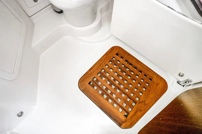  Yacht Photos Pics 2025 Grady-White Canyon 456 boat interior with wooden floor grate and white fixtures.