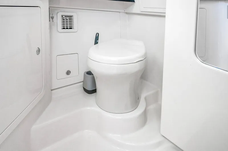  Yacht Photos Pics 2025 Grady-White Canyon 456 boat bathroom with modern white toilet and compact design.