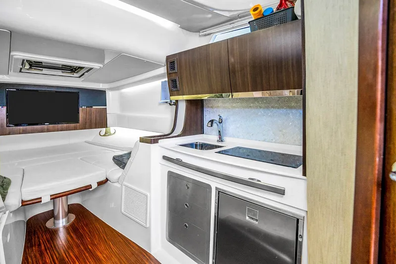  Yacht Photos Pics Luxurious interior of 2025 Grady-White Canyon 456 boat with modern kitchenette and seating area.