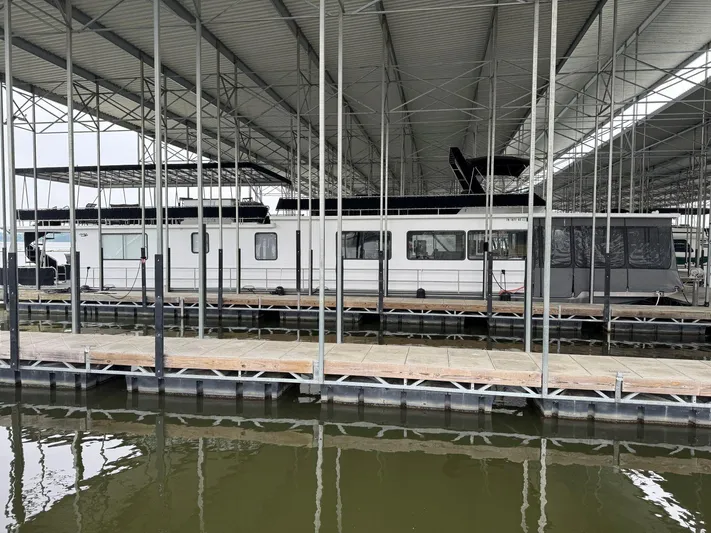  Yacht Photos Pics 1986 Stardust Cruisers 18 X 80 houseboat docked in a covered marina.