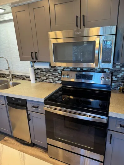  Yacht Photos Pics Modern kitchen in 1986 Stardust Cruisers houseboat with stainless steel appliances and mosaic backsplash.