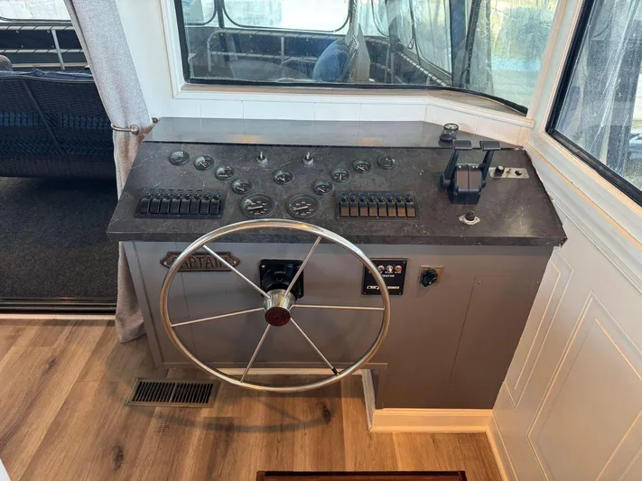  Yacht Photos Pics Control panel of a 1986 Stardust Cruisers 18 X 80 houseboat with steering wheel and gauges.