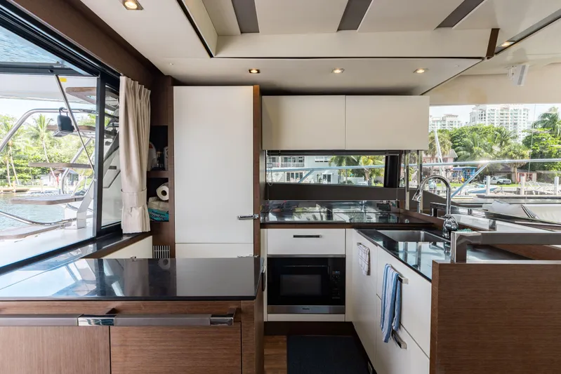 Knightlife Yacht Photos Pics Modern kitchen interior on 2017 Prestige 630 yacht, featuring sleek cabinetry and waterfront views.