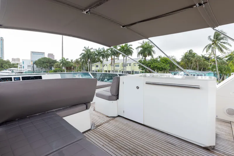 Knightlife Yacht Photos Pics Luxurious 2017 Prestige 630 yacht deck with seating, surrounded by palm trees and cityscape.