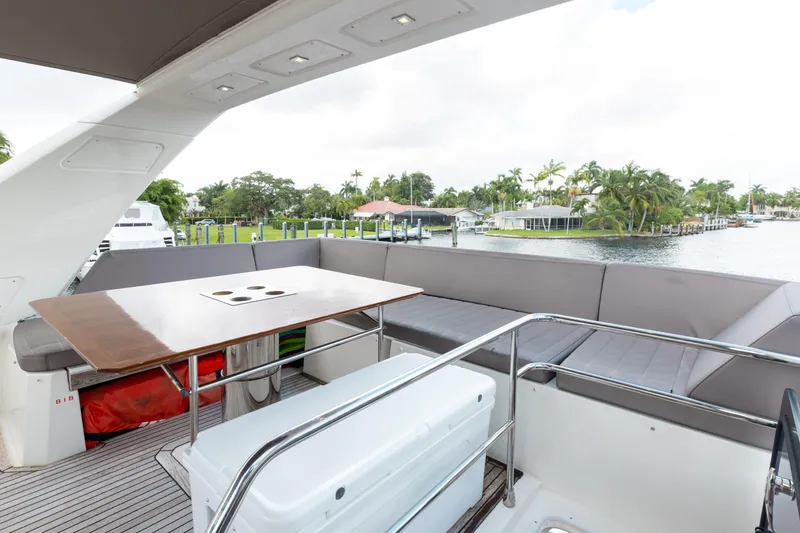 Knightlife Yacht Photos Pics Luxurious 2017 Prestige 630 yacht deck with seating and table, overlooking serene waterfront.