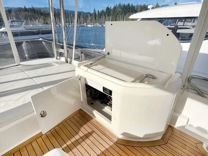  Yacht Photos Pics 2018 Ferretti Yachts 550 deck with open storage, wooden flooring, and scenic marina view.