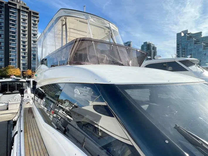  Yacht Photos Pics Ferretti Yachts 550, 2018 model, docked with cityscape background and clear blue sky.