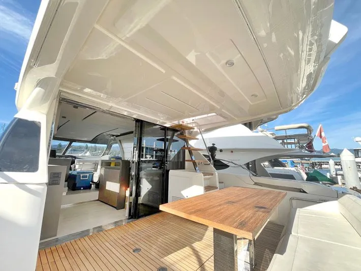  Yacht Photos Pics 2018 Ferretti Yachts 550, spacious deck with wooden table, marina view.