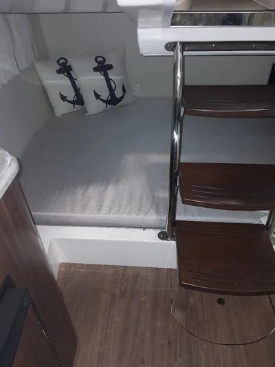 Northern Exposure II Yacht Photos Pics 2018 Regal 28 Express cabin interior with anchor-themed pillows and wooden steps.