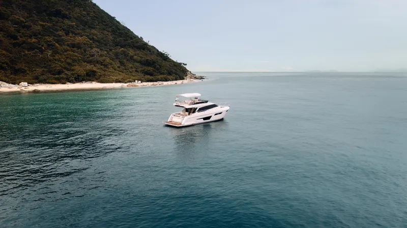  Yacht Photos Pics 2022 Ferretti Yachts 500 cruising near a scenic coastline.
