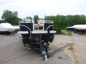 2024 Sun Tracker Sportfish 24 XP3 pontoon boat on trailer, parked outdoors.