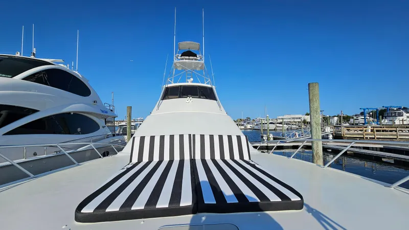  Yacht Photos Pics Ocean Yachts 70 Super Sport 2000 with striped sunbed, docked at marina under clear blue sky.