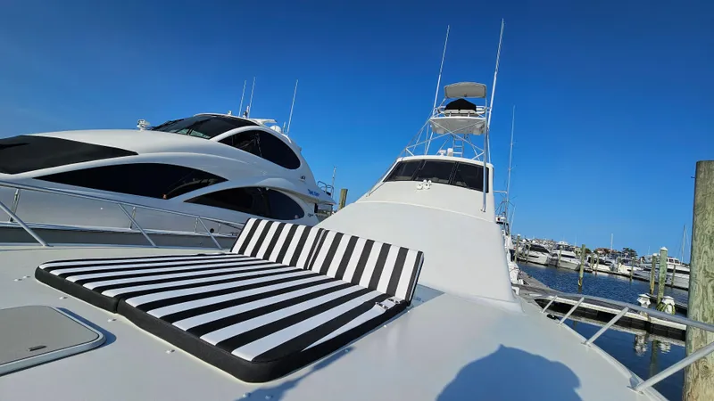  Yacht Photos Pics Ocean Yachts 70 Super Sport 2000 with striped sunbed, docked at marina under clear blue sky.