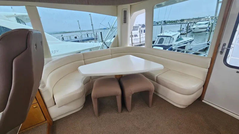  Yacht Photos Pics Interior of 2000 Ocean Yachts 70 Super Sport with white seating and triangular table.