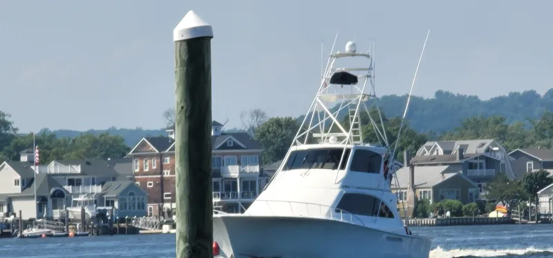  Yacht Photos Pics Ocean Yachts 70 Super Sport 2000 cruising near waterfront homes and dock.