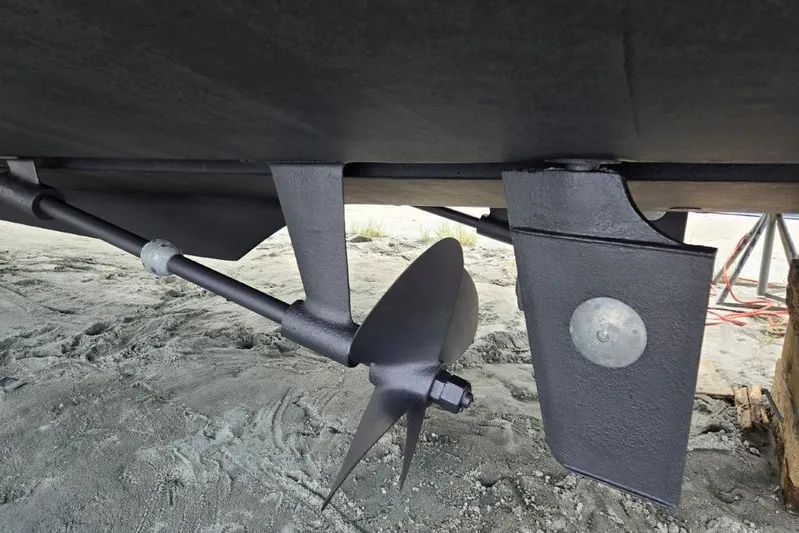 Everyday Yacht Photos Pics Close-up of 2003 Silverton 453 Motor Yacht propeller and rudder on sandy ground.