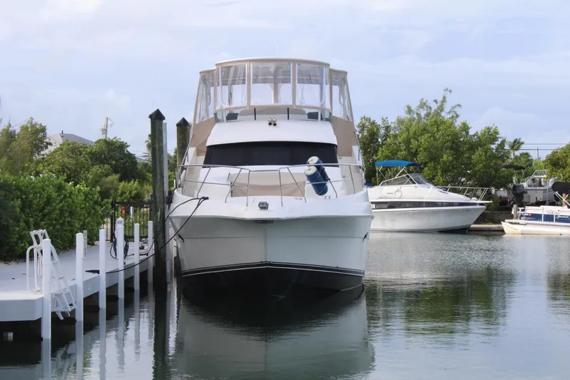 Everyday Yacht Photos Pics 2003 Silverton 453 Motor Yacht docked in a serene marina setting.