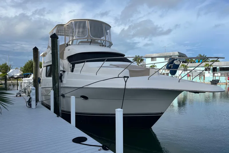 Everyday Yacht Photos Pics 2003 Silverton 453 Motor Yacht docked at marina under cloudy sky.