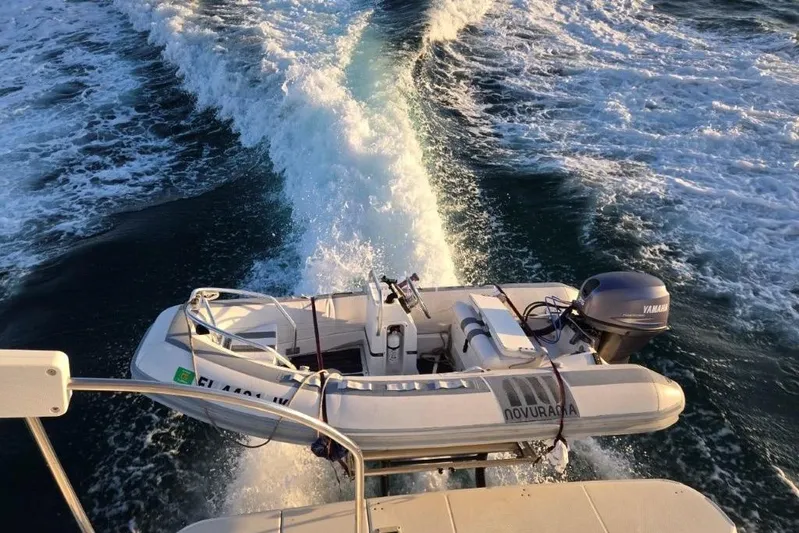 Everyday Yacht Photos Pics 2003 Silverton 453 Motor Yacht with dinghy on ocean, creating a wake.