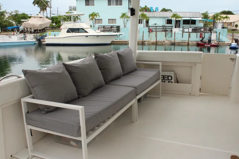 Everyday Yacht Photos Pics 2003 Silverton 453 Motor Yacht deck with gray cushioned seating, docked near waterfront homes.