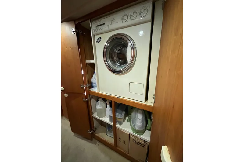 Everyday Yacht Photos Pics Laundry area inside 2003 Silverton 453 Motor Yacht with washer and storage shelves.