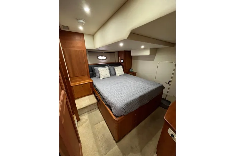 Everyday Yacht Photos Pics Interior of 2003 Silverton 453 Motor Yacht bedroom with cozy bed and wooden cabinetry.