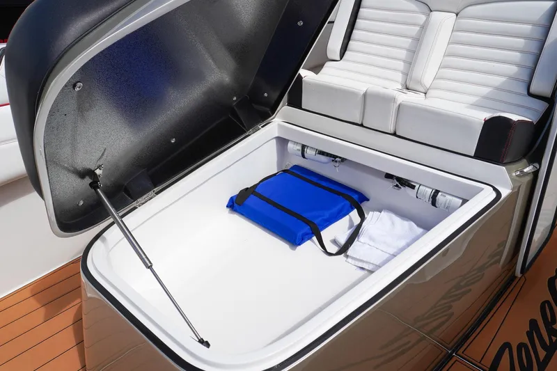  Yacht Photos Pics 2023 Renegade 38 GTS Open boat storage compartment with blue bag and towel.