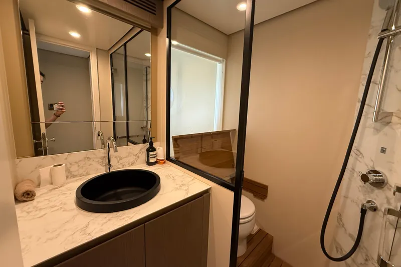  Yacht Photos Pics Luxurious bathroom in 2024 Azimut Magellano 60 yacht with modern fixtures and marble accents.