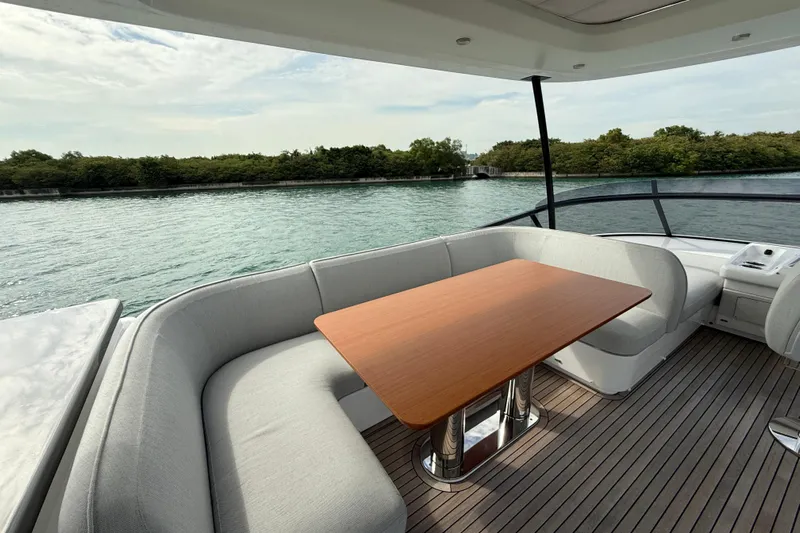  Yacht Photos Pics Luxurious 2024 Azimut Magellano 60 yacht deck with elegant seating and scenic water view.