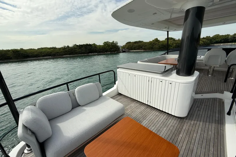  Yacht Photos Pics Luxurious 2024 Azimut Magellano 60 yacht deck with elegant seating and scenic water view.