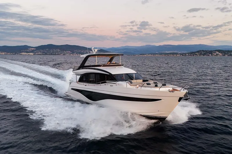  Yacht Photos Pics Luxurious 2025 Princess Y72 yacht cruising on open water at sunset.