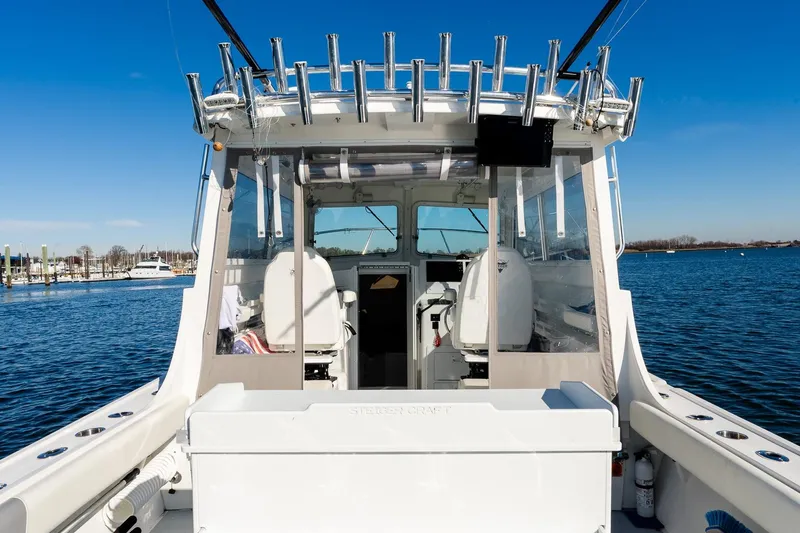 Yacht Photos Pics 2024 Steiger Craft 31 Fisherman boat, rear view, docked on calm water under clear blue sky.
