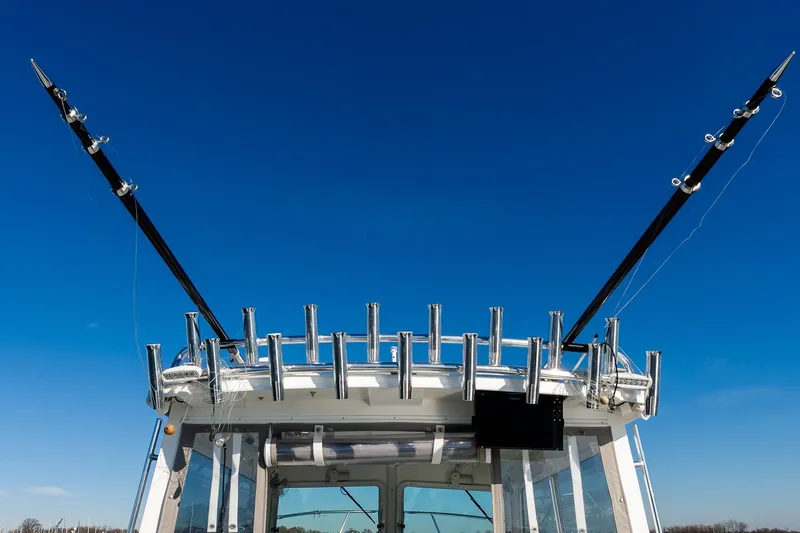  Yacht Photos Pics 2024 Steiger Craft 31 Fisherman boat with fishing rod holders against clear blue sky.