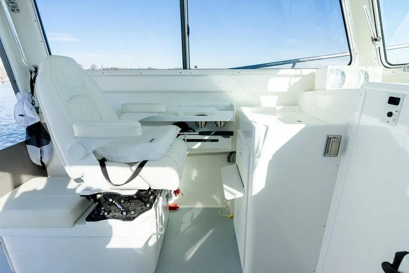  Yacht Photos Pics 2024 Steiger Craft 31 Fisherman interior with white captain's chair and control panel.