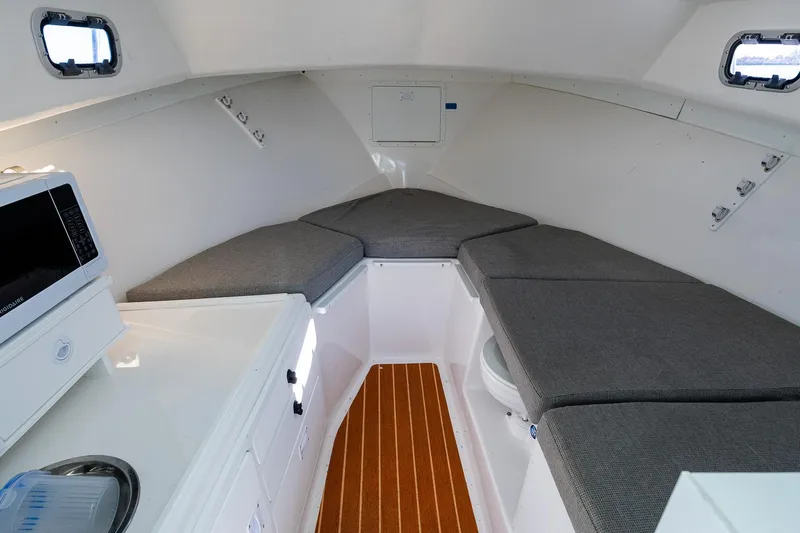  Yacht Photos Pics 2024 Steiger Craft 31 Fisherman cabin interior with seating, microwave, and wood flooring.