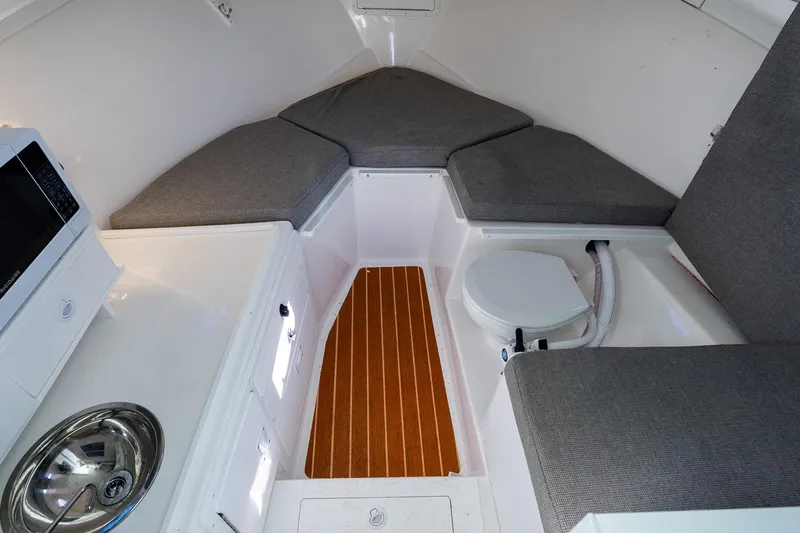  Yacht Photos Pics 2024 Steiger Craft 31 Fisherman cabin interior with seating, sink, and microwave.