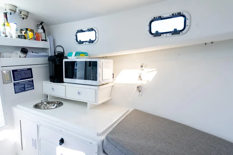  Yacht Photos Pics 2024 Steiger Craft 31 Fisherman interior with kitchenette, microwave, and seating area.