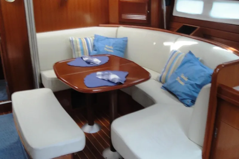  Yacht Photos Pics Interior of 2006 Beneteau Oceanis Clipper 423 yacht with cozy seating and wooden table.