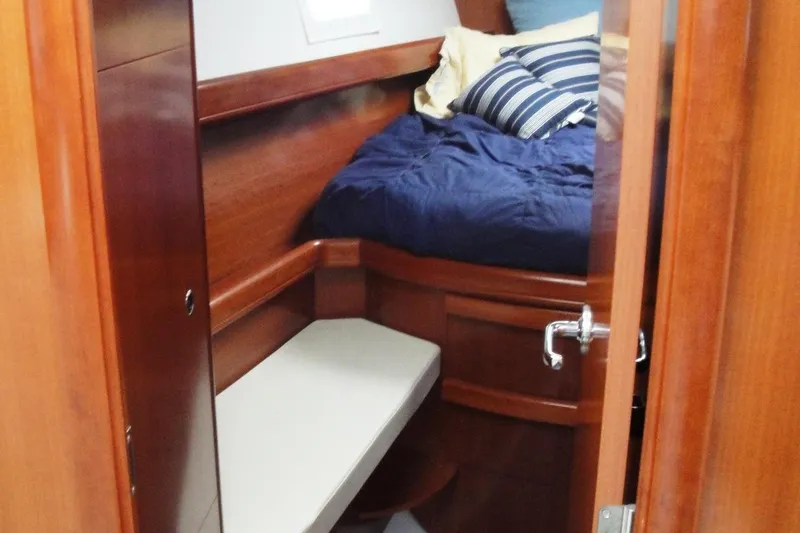  Yacht Photos Pics Interior cabin of 2006 Beneteau Oceanis Clipper 423 with wooden finish and cozy bedding.