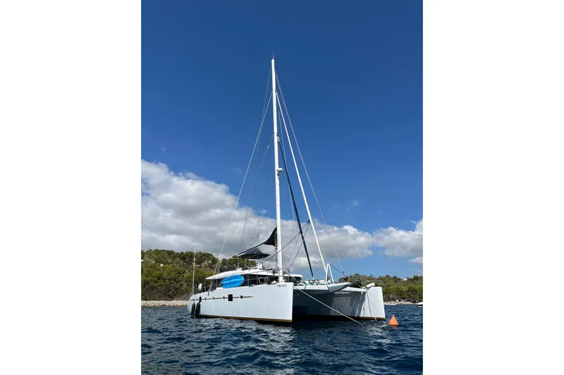 Sunreef 60 Yacht Photos Pics Sailing catamaran Sunreef 60, 2005 model, anchored in clear blue waters.