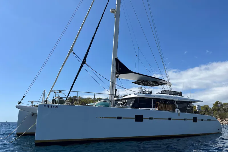 Sunreef 60 Yacht Photos Pics 2005 Sunreef 60 catamaran sailing on clear blue waters under a sunny sky.