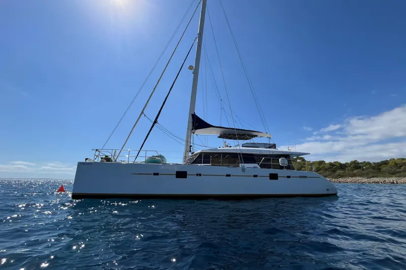 Sunreef 60 Yacht Photos Pics 2005 Sunreef 60 catamaran sailing on a sunny day, with clear blue skies and calm waters.