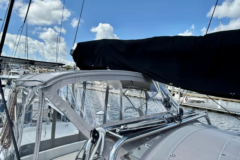 Su Ching Yacht Photos Pics 1984 Tayana 55 sailboat docked, featuring a covered cockpit and clear skies.