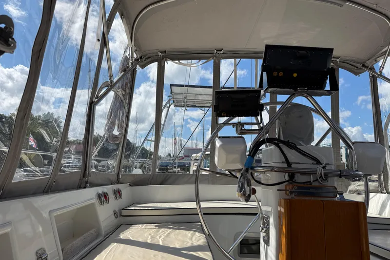 Su Ching Yacht Photos Pics Interior view of 1984 Tayana 55 sailboat cockpit with steering wheel and navigation equipment.