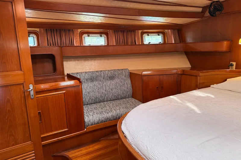 Su Ching Yacht Photos Pics Luxurious 1984 Tayana 55 yacht interior with wood paneling and cozy seating area.
