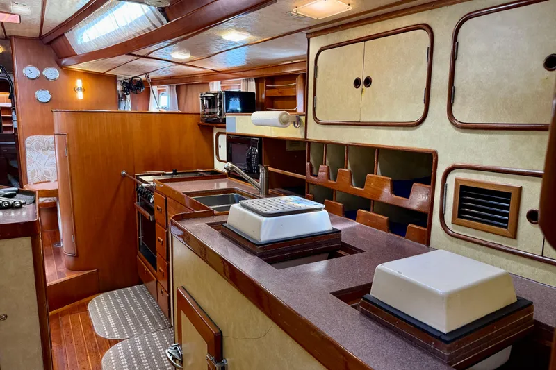 Su Ching Yacht Photos Pics Interior of 1984 Tayana 55 yacht with wooden cabinetry and modern kitchen amenities.