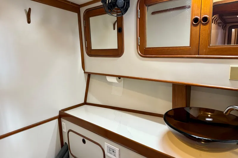 Su Ching Yacht Photos Pics 1984 Tayana 55 yacht interior with wooden cabinets and modern glass sink.