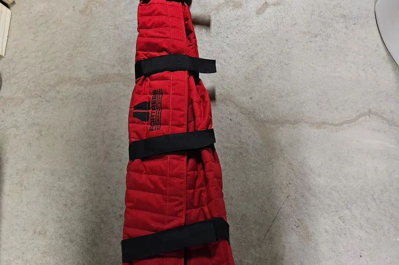 Su Ching Yacht Photos Pics Red padded cover with black straps on a concrete floor, labeled "Fortress."